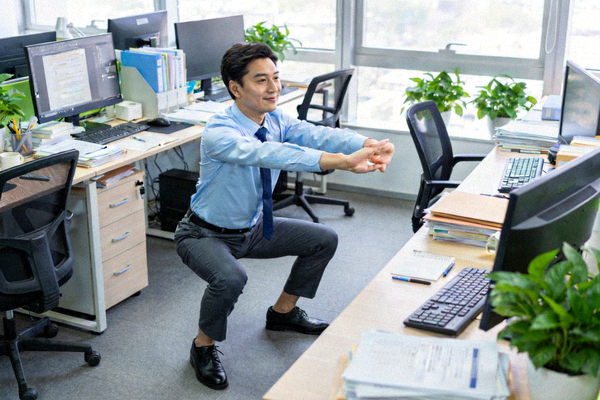 办公室白领利用午休时间在工位旁进行短时趣味健身挑战，缓解久坐疲劳